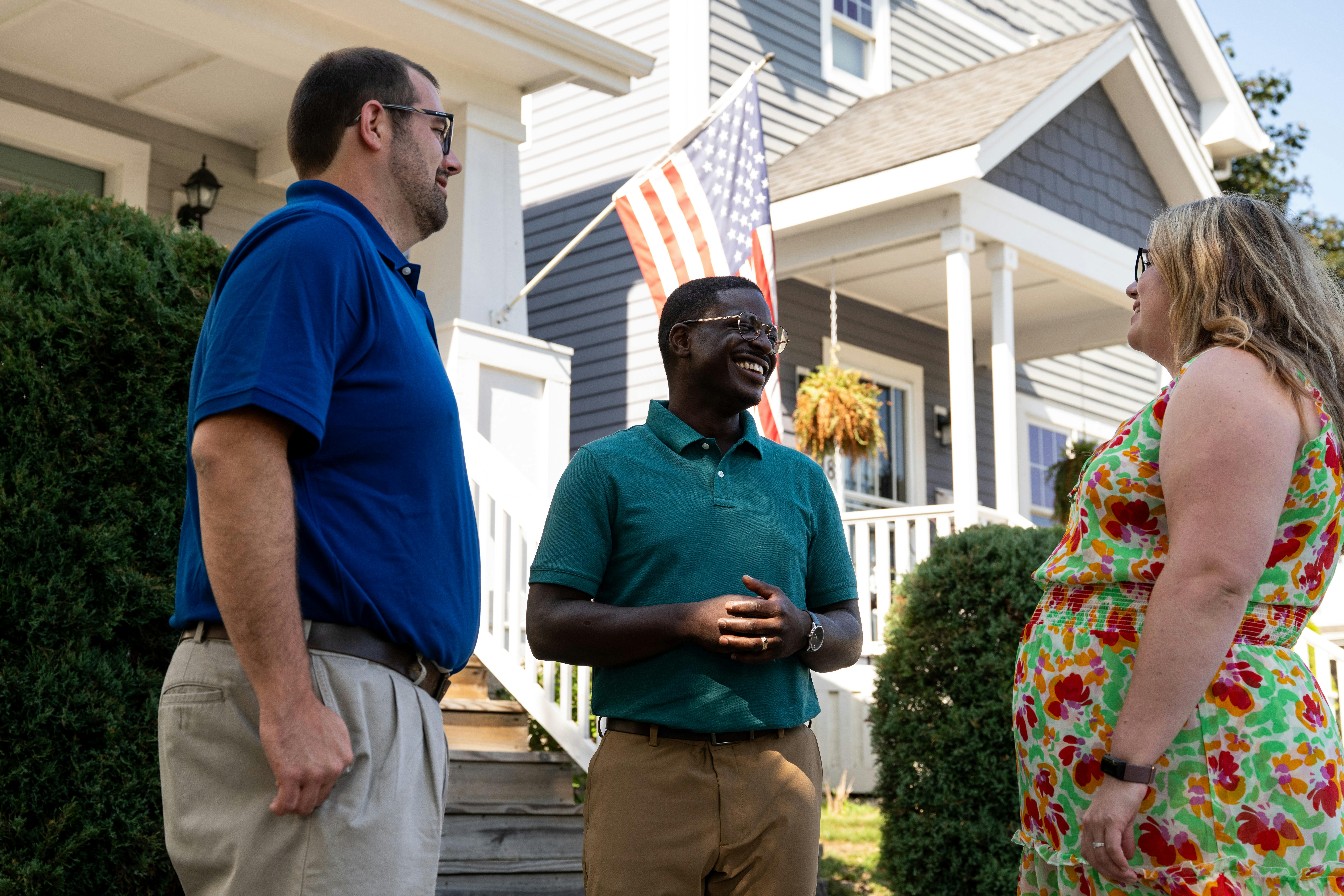 David standing outside of a house with two homeowners