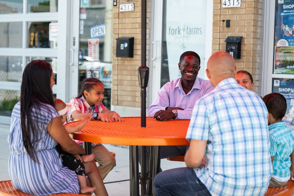 A photo of David at a picnic table with a family