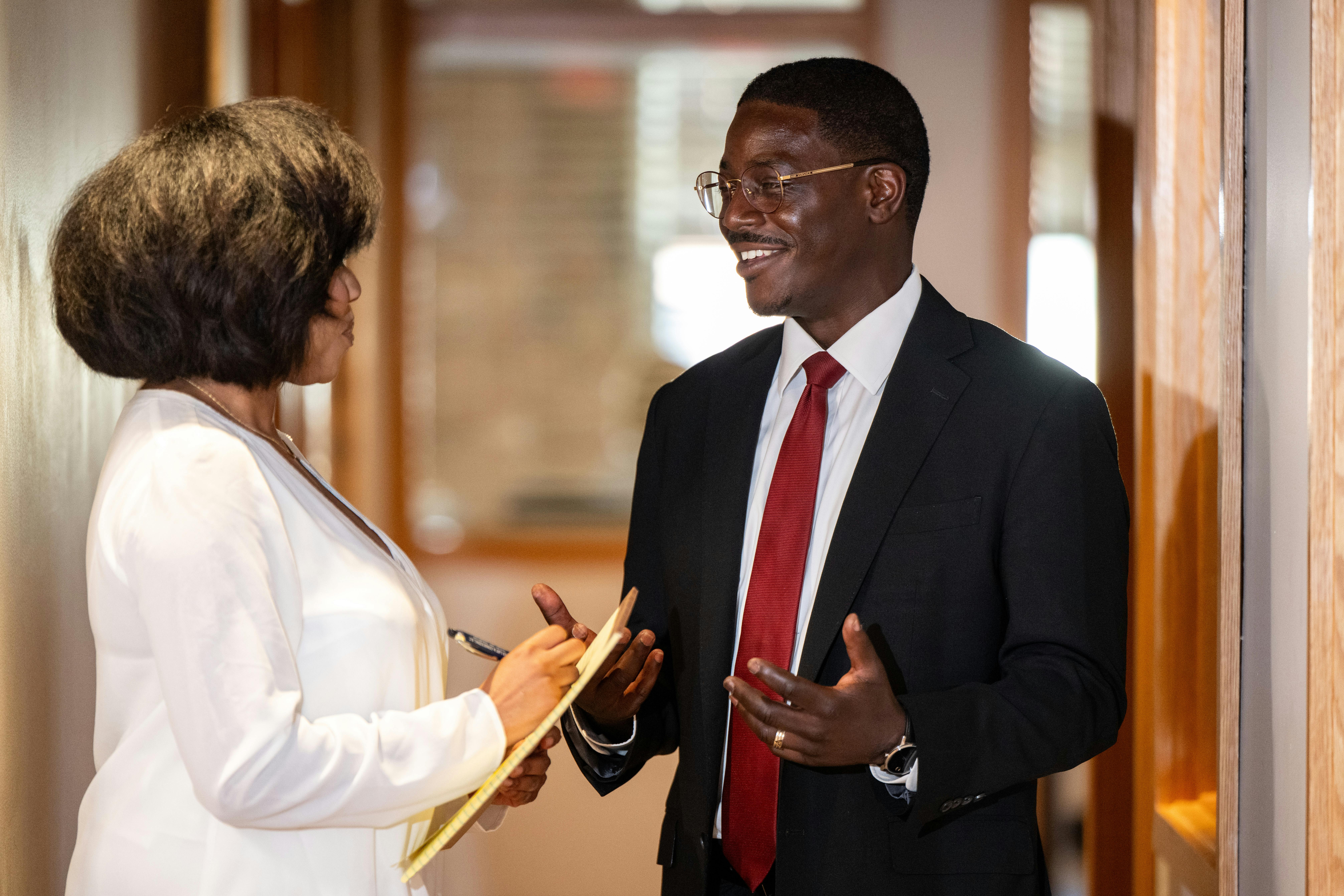 A photo of David talking to someone in a hallway