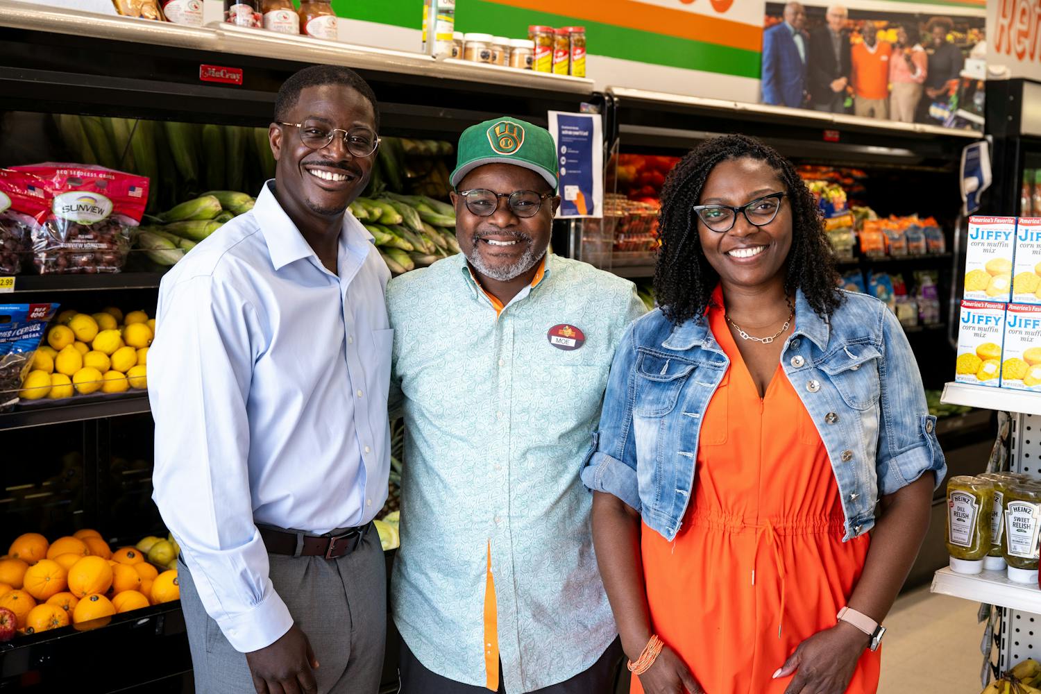 A photo of David smiling with two others in a grocery store