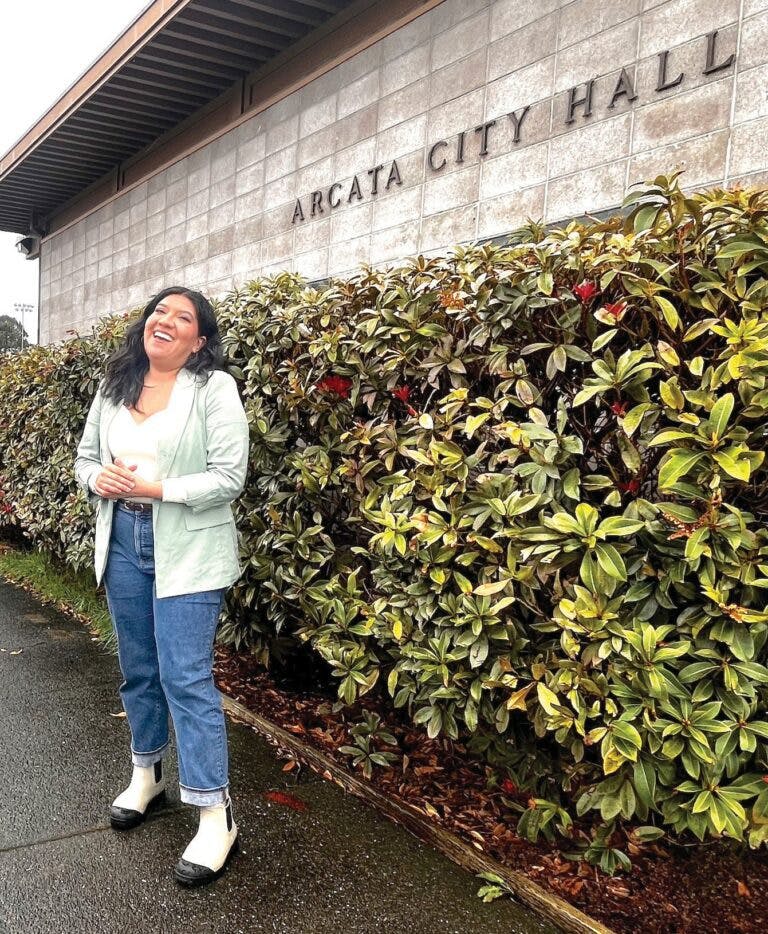 Genevieve standing in front of Arcata City Hall while laughing.