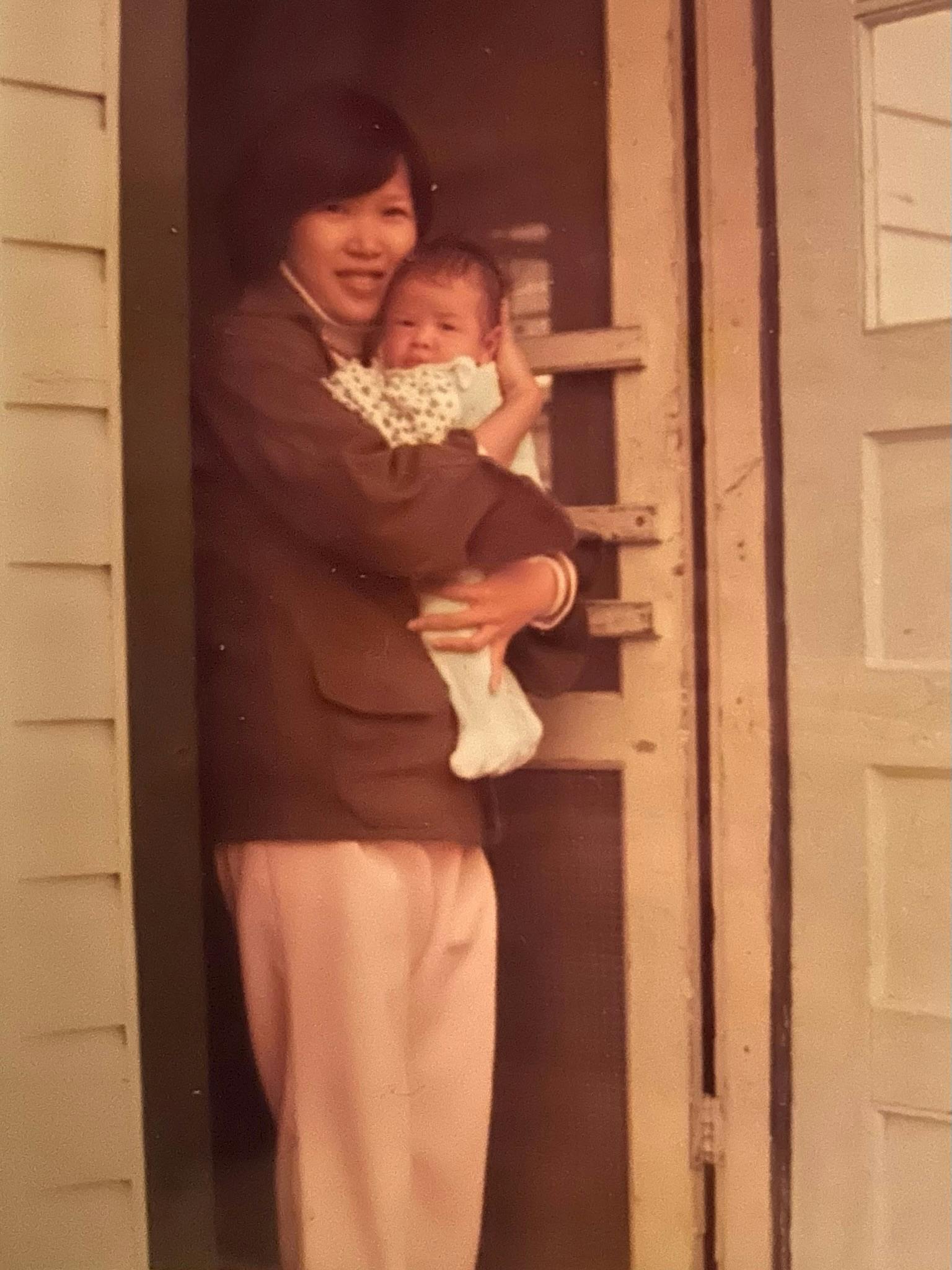Old photo of candidate Dr. Quy Tran as an infant being held by his mother.