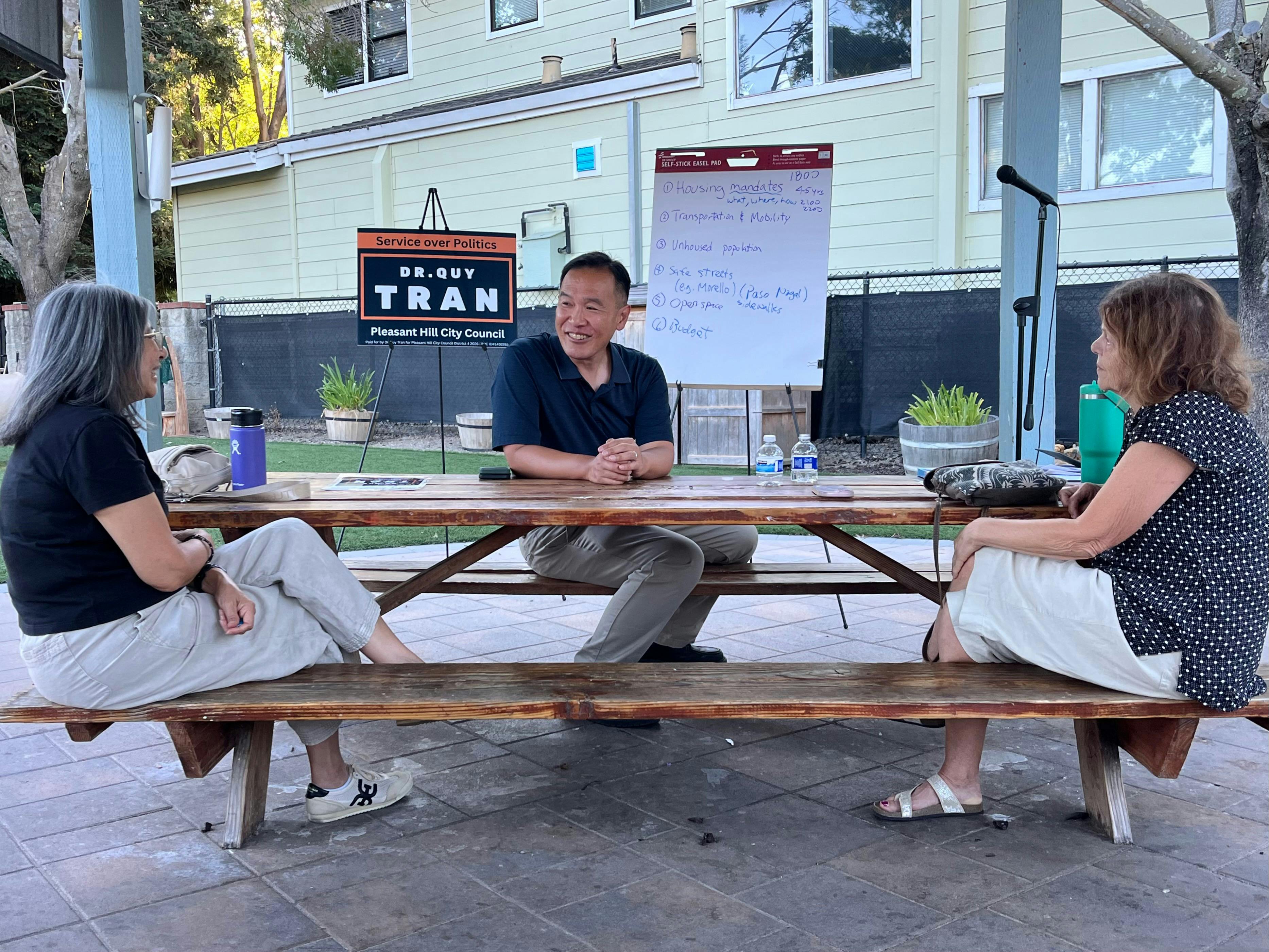 Portrait of Dr. Quy Tran at a townhall hosted at Center of Gravity speaking with residents of District 4