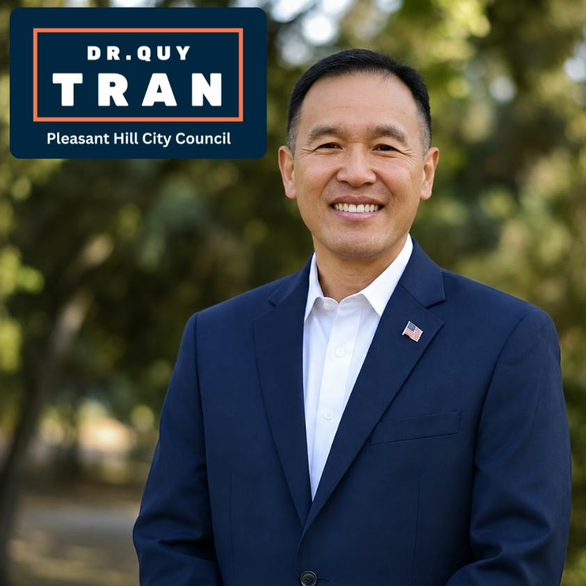 Portrait of Pleasant Hill District 4 candidate Dr. Quy Tran in a navy blue suit and smiling.