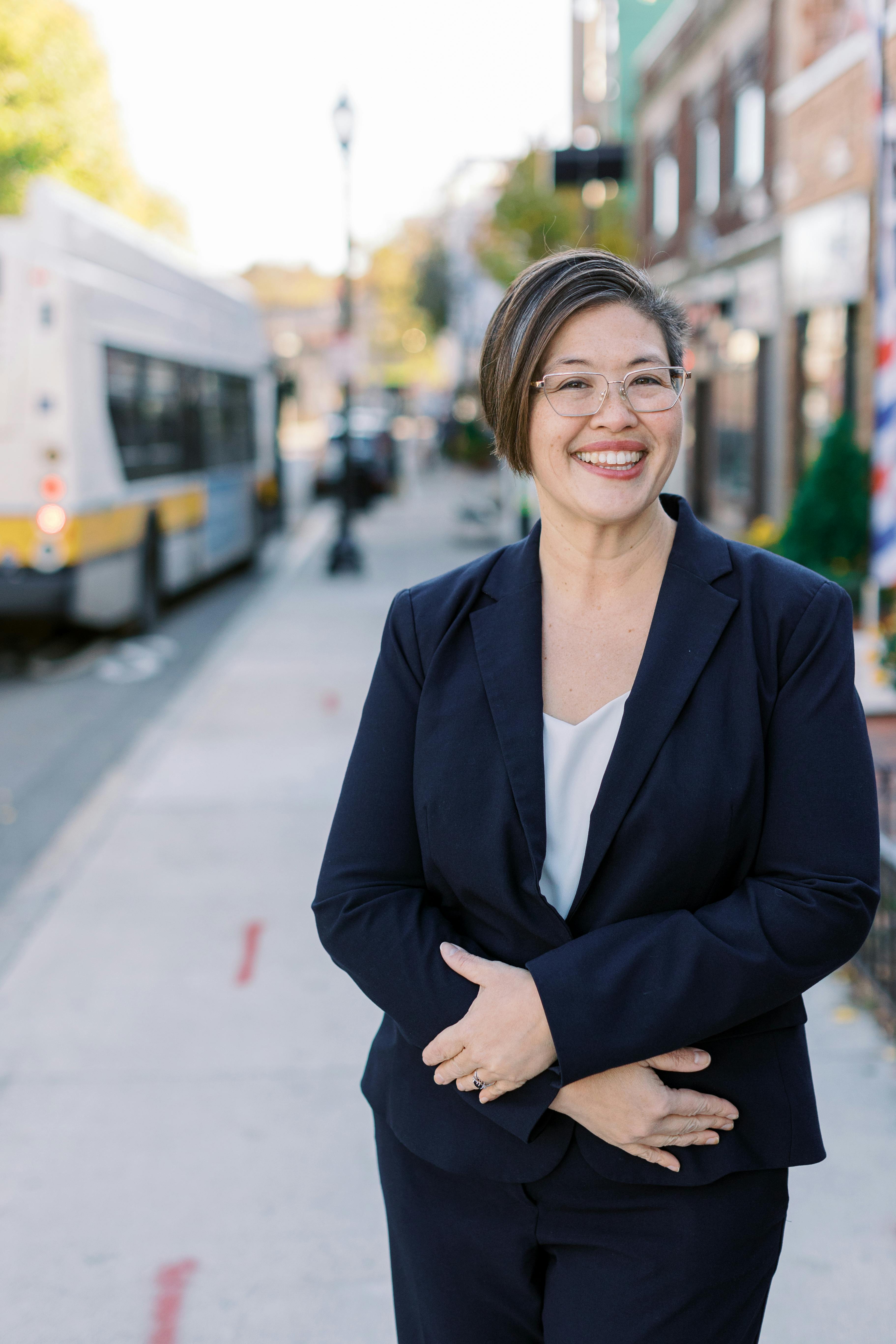 Persis Yu standing on a business street in Roslindale