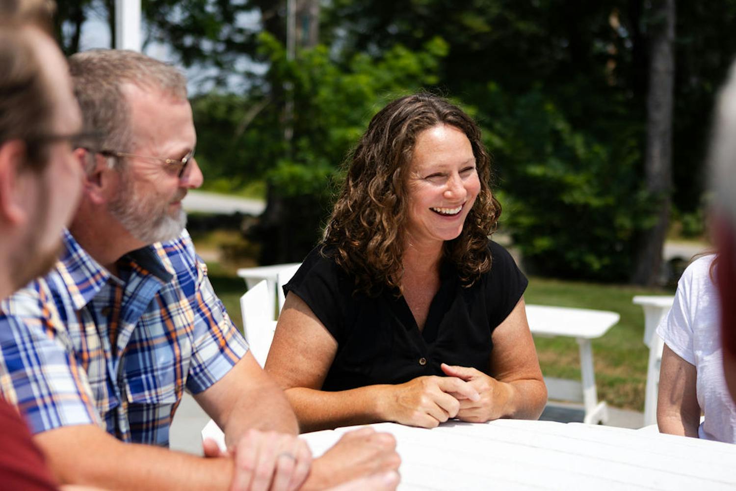 Candidate speaking with others at table outdoors