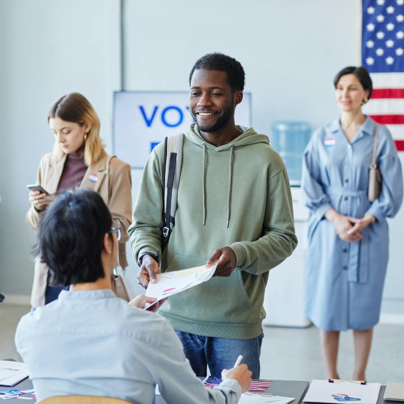 Man turning in his completed ballot at a polling place.
