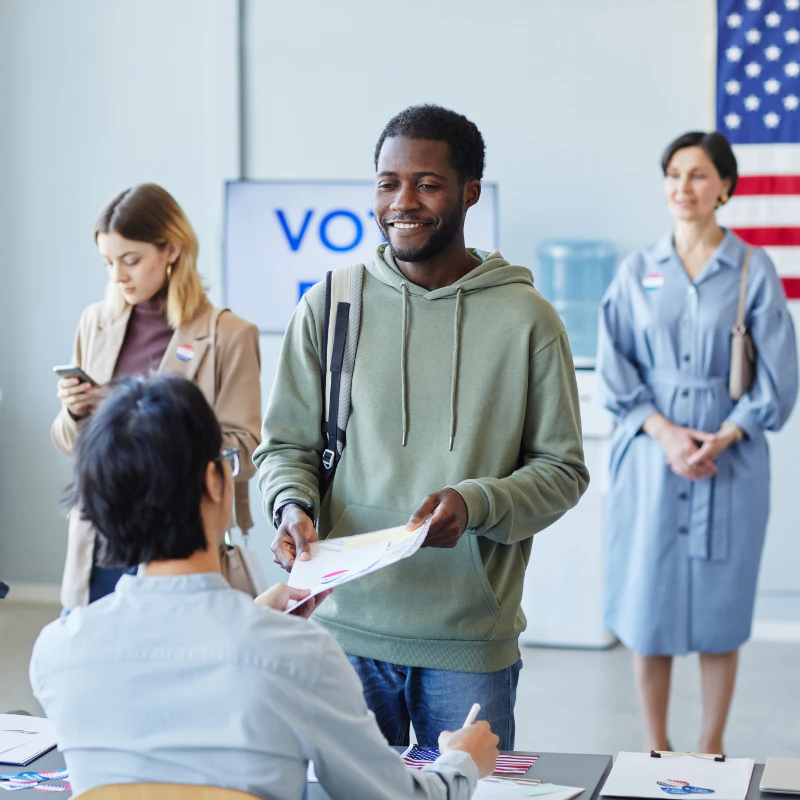 Man turning in his completed ballot at a polling place.