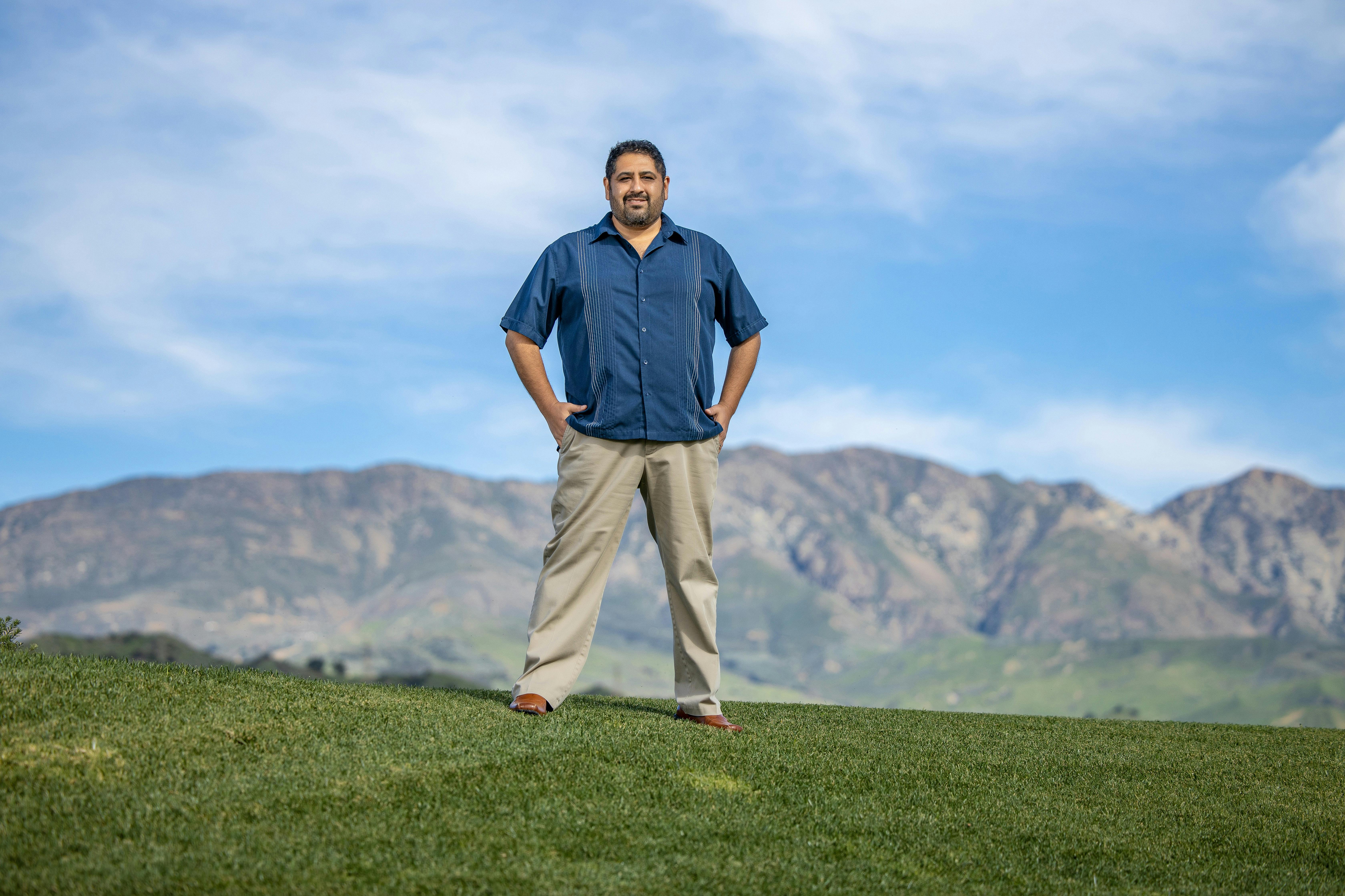 photo of Chris Espinosa, mountains on the background with clouds in the sky