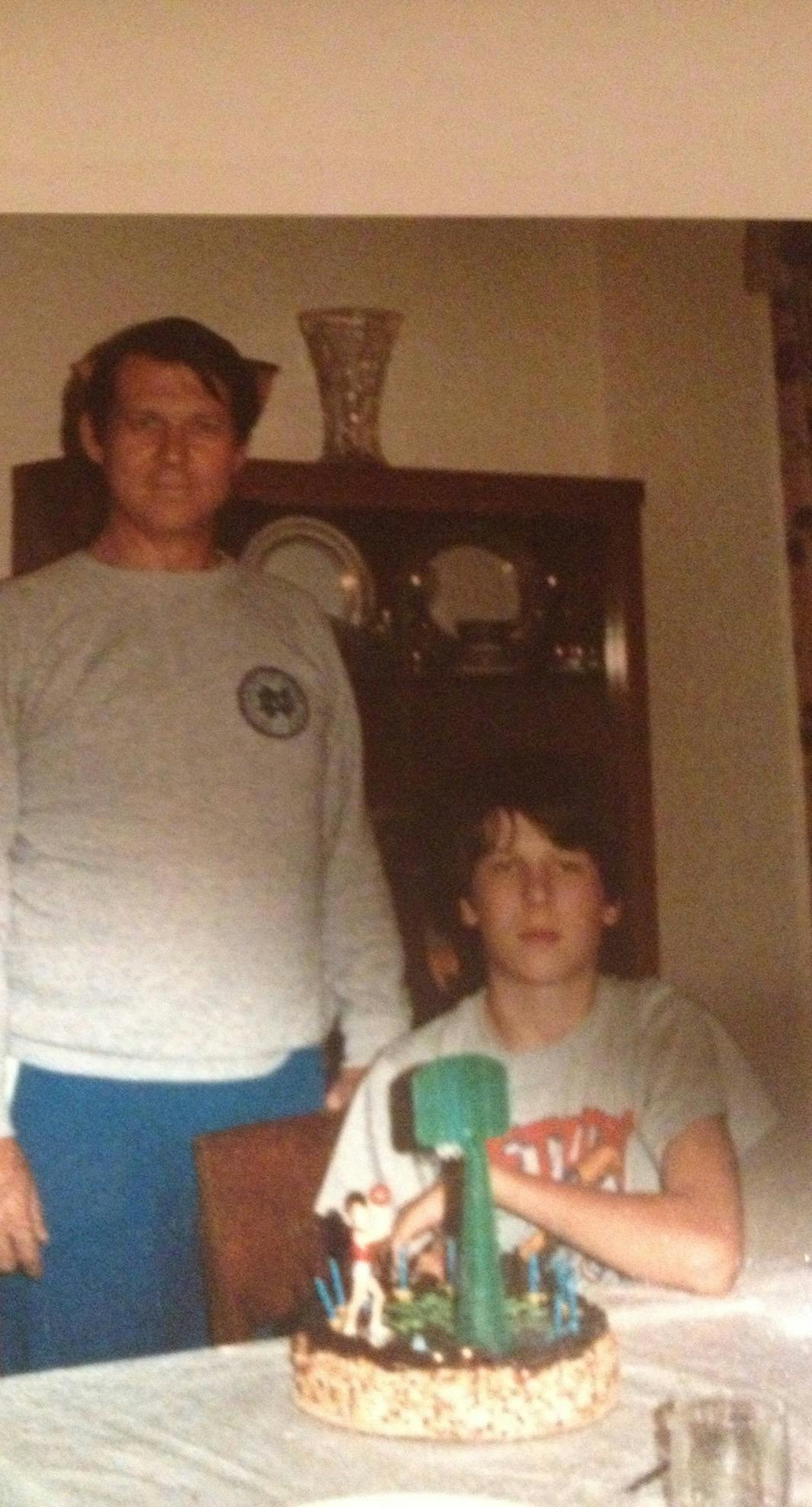 Bill as a child sitting at a table next to his father