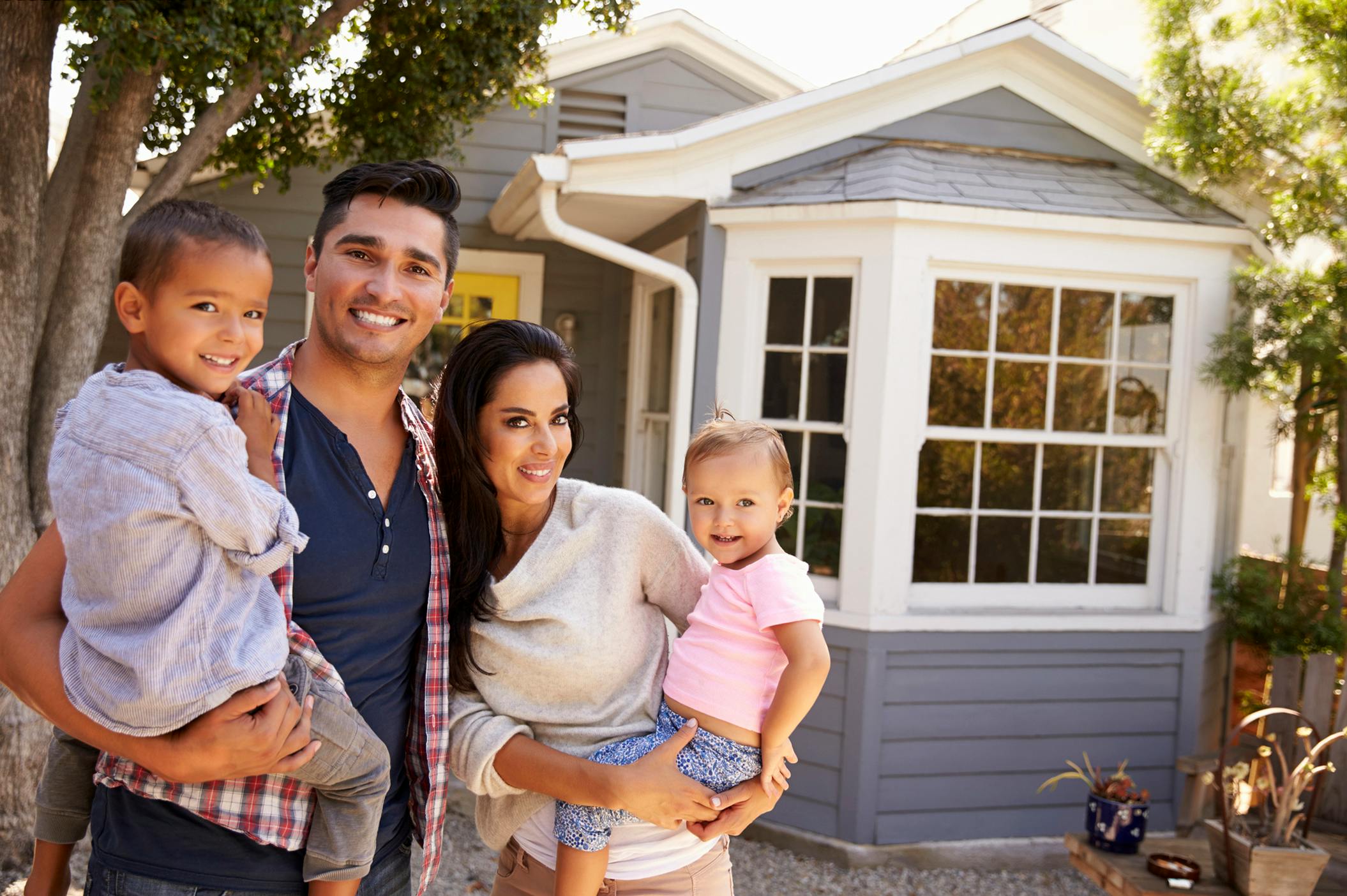 Portrait of family in front of home