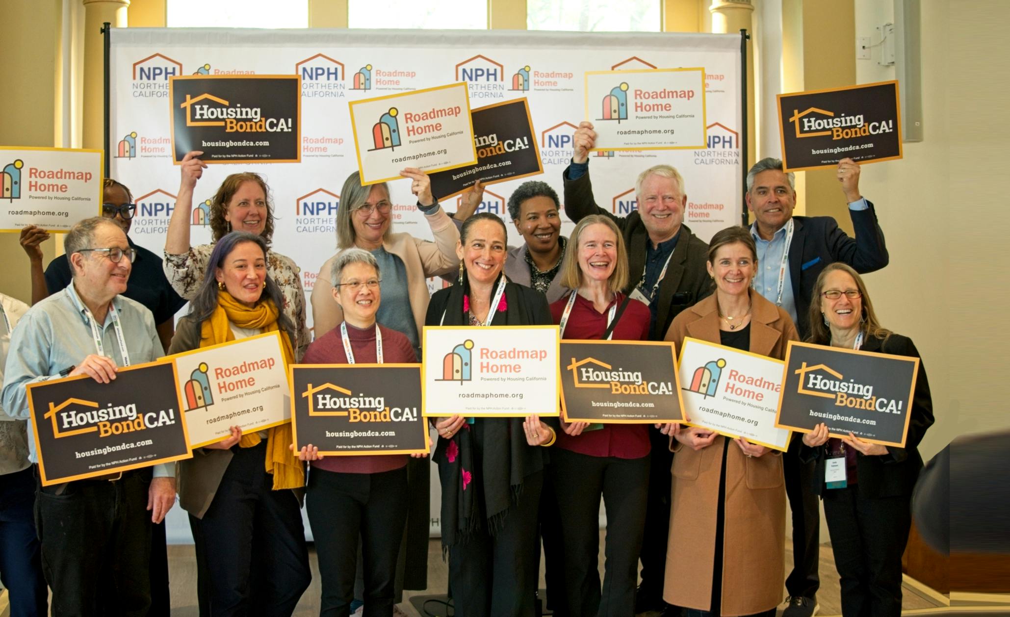 Portrait of group holding Roadmap Home signs