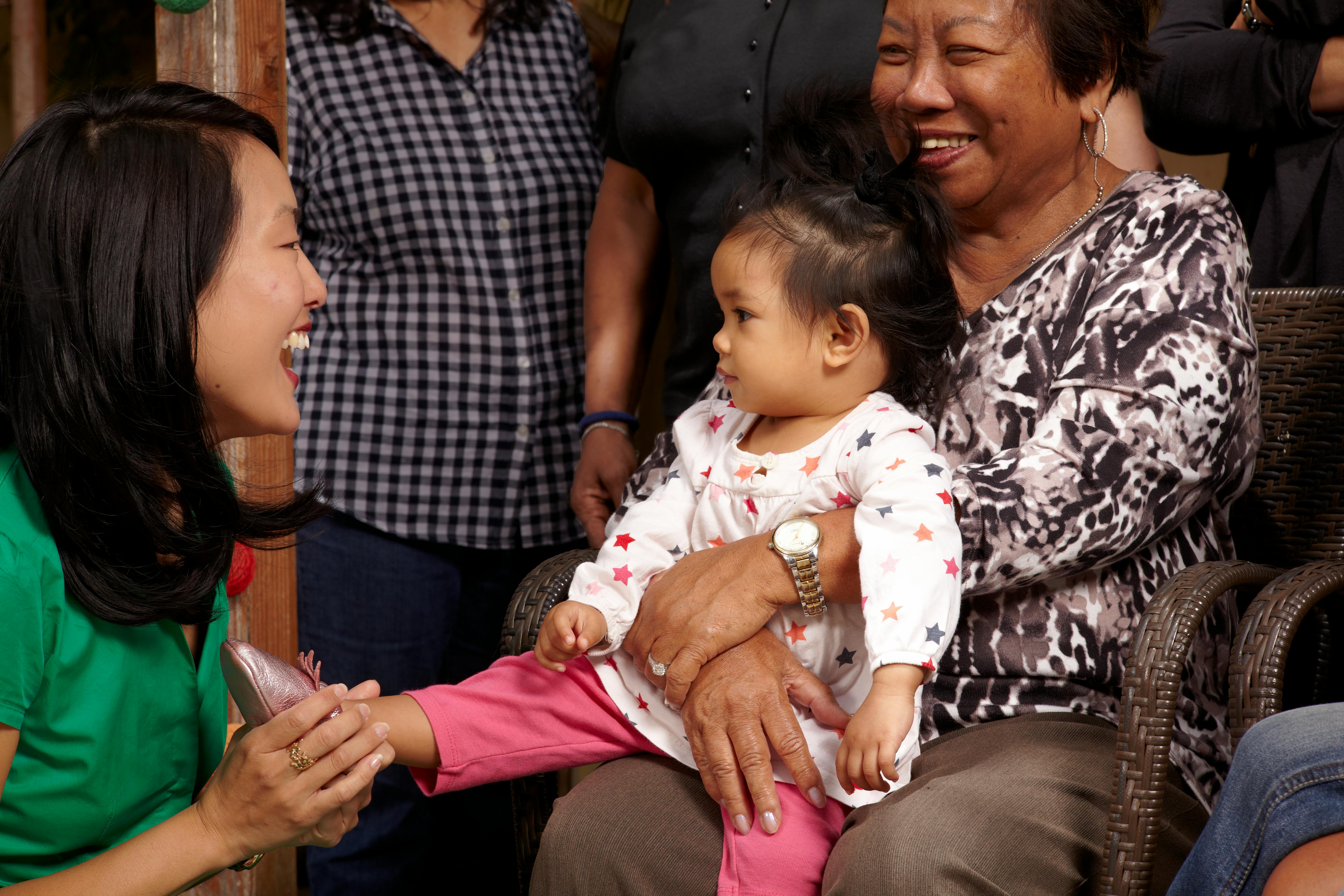 Jane Kim laughing with a child and their mother