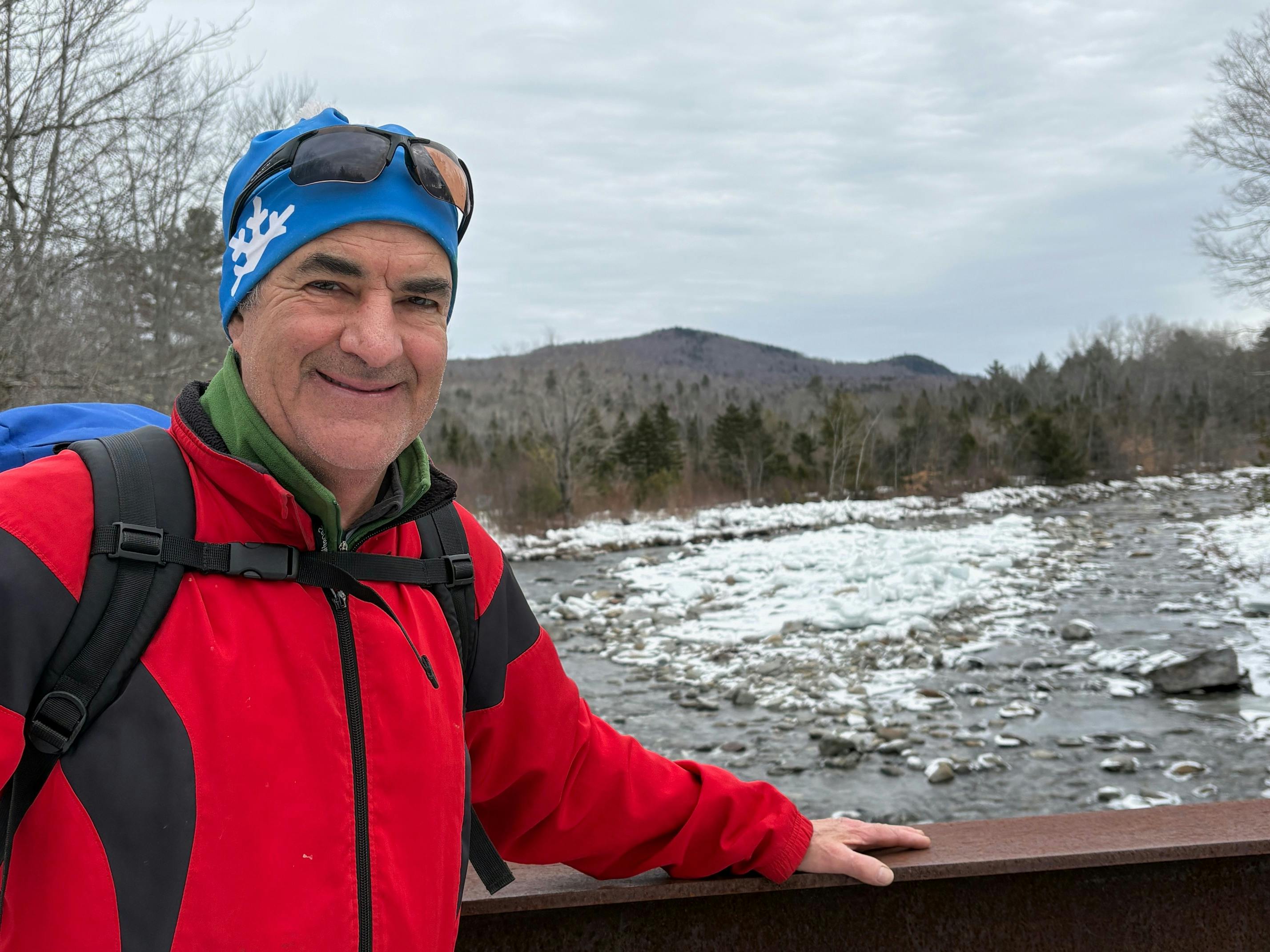 Portrait of candidate smiling in front of river during winter