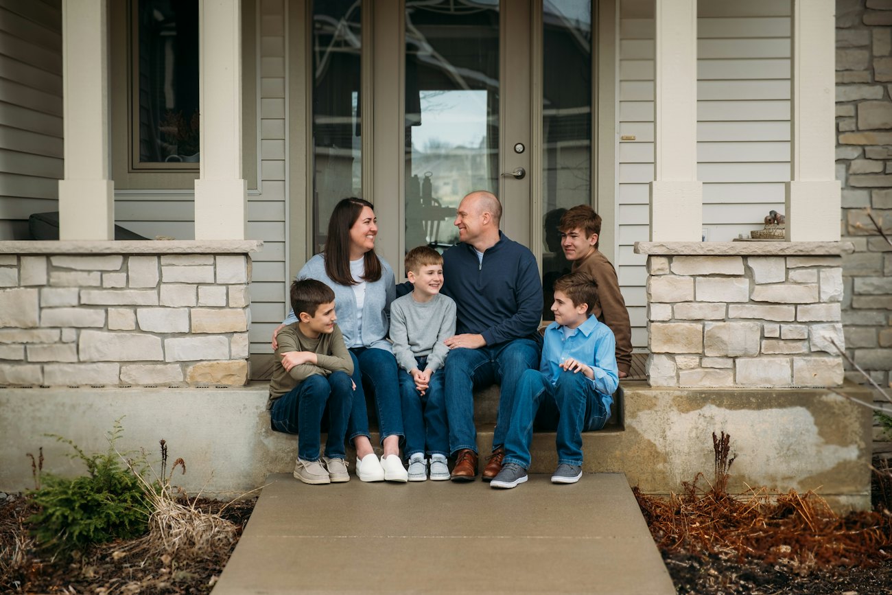 Jake Johnson with his wife Molly and their four boys on their front steps