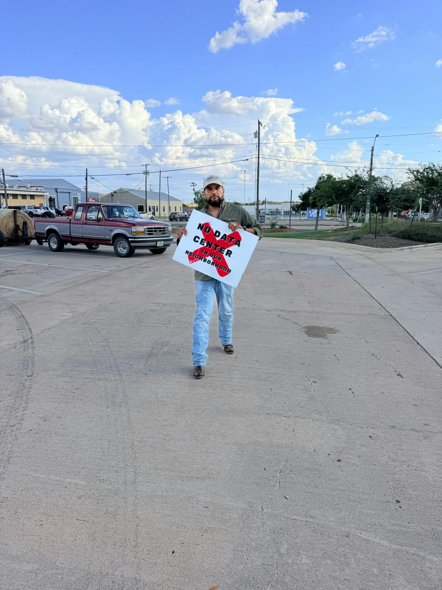 Chris Jimenez holding a sign that says "No Data Center in our neighborhood"