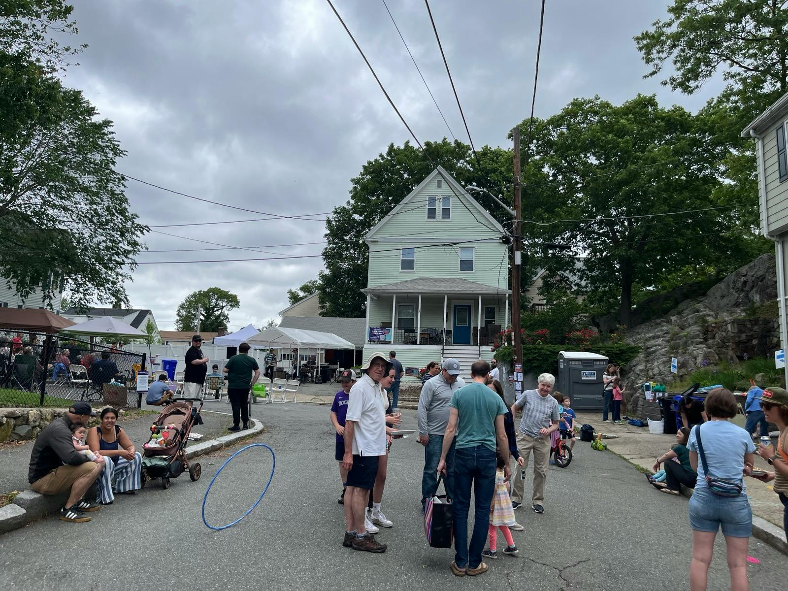 Friends and neighbors are hanging out at a block party, with music in the background