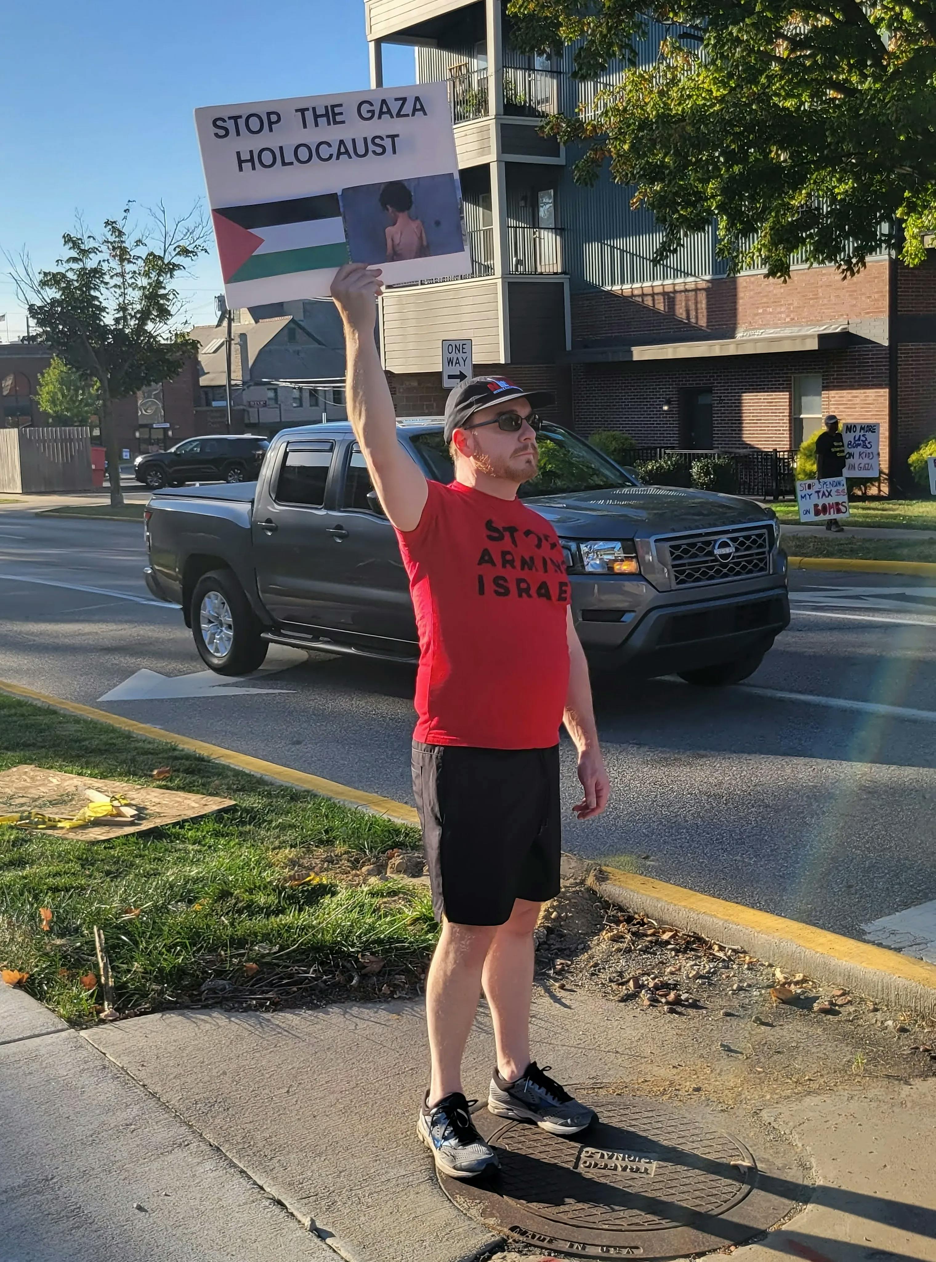 Ben holding Stop the Gaza Holocaust sign and wearing Stop Arming Israel shirt