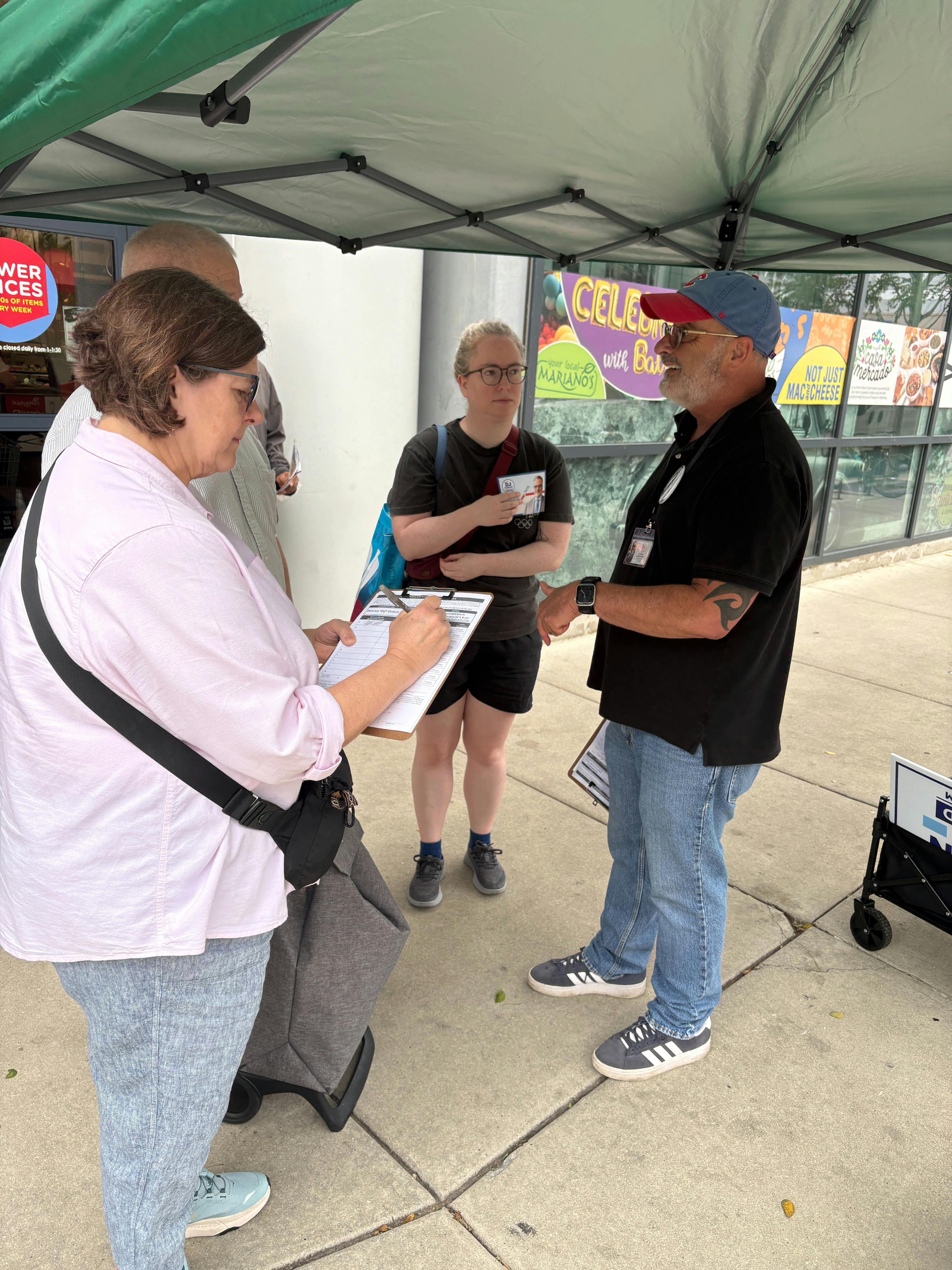 DJ engaging with voters signing petitions