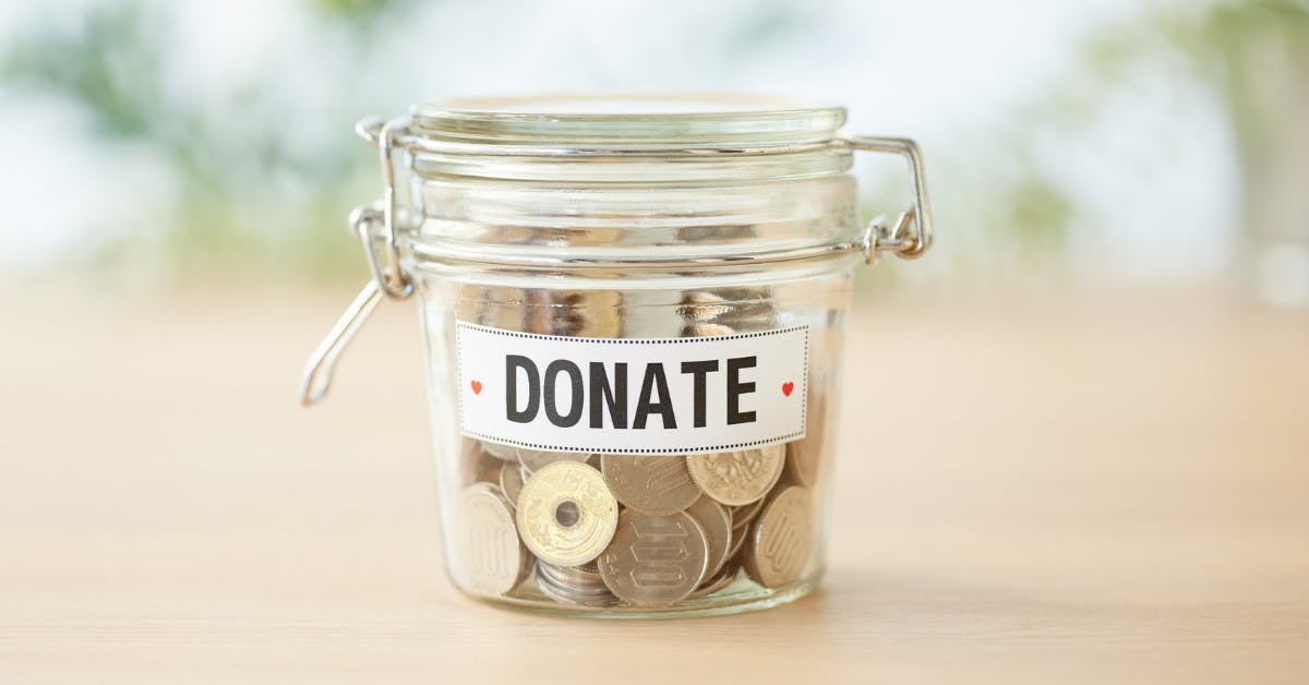 glass coin jar with the label "donate" on it