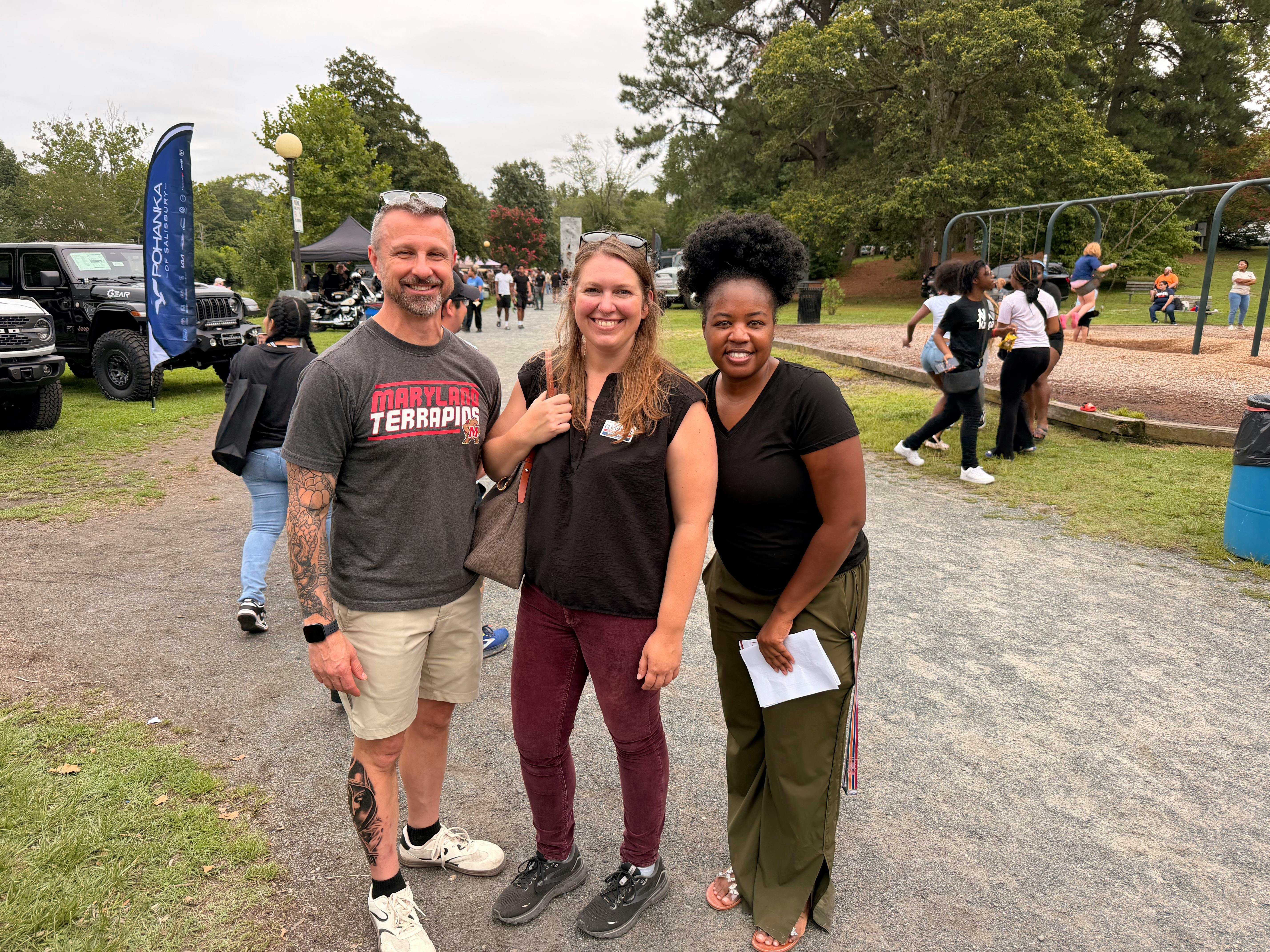 Katie Clendaniel smiling with two community members at an outdoor event