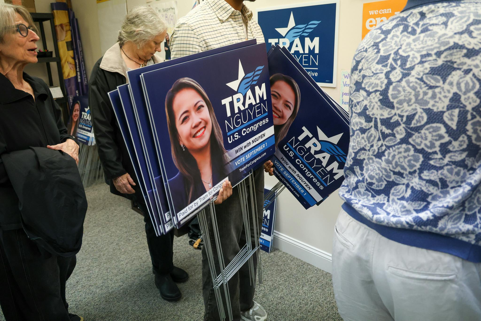 Photo of a volunteer holding Tram Nguyen for Congress yard signs.