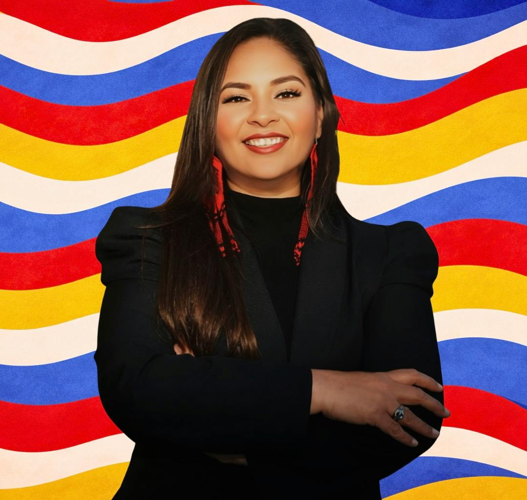Maria Pacheco with arms folded on bright wavy background