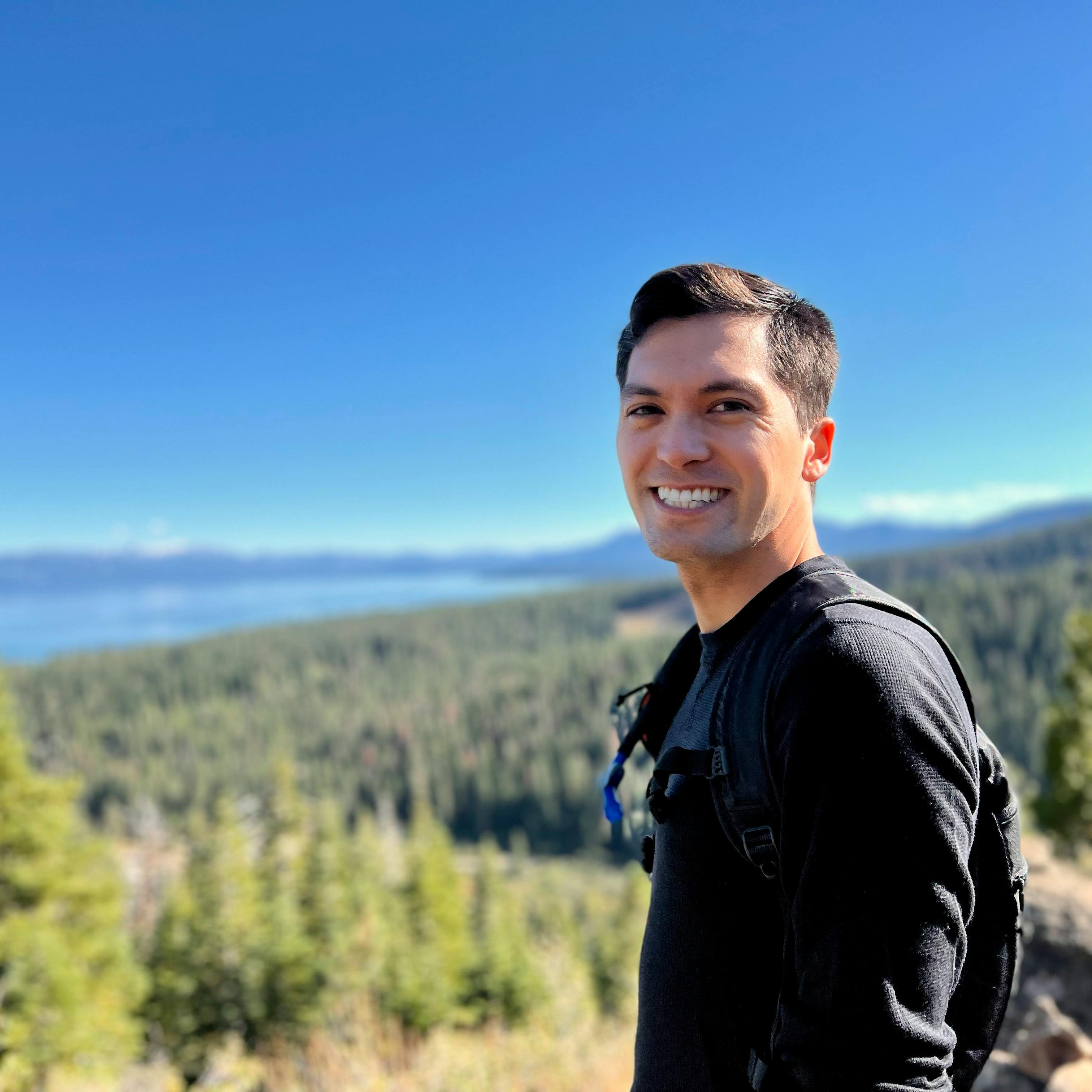 Jason Toups standing on a summit above Lake Tahoe