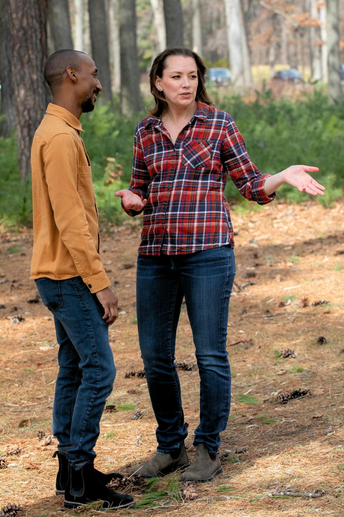 Sarah speaking with a neighbor in a wooded clearing